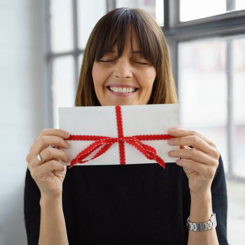 happy woman holding gift card with red bow