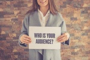 woman holding who is your audience sign
